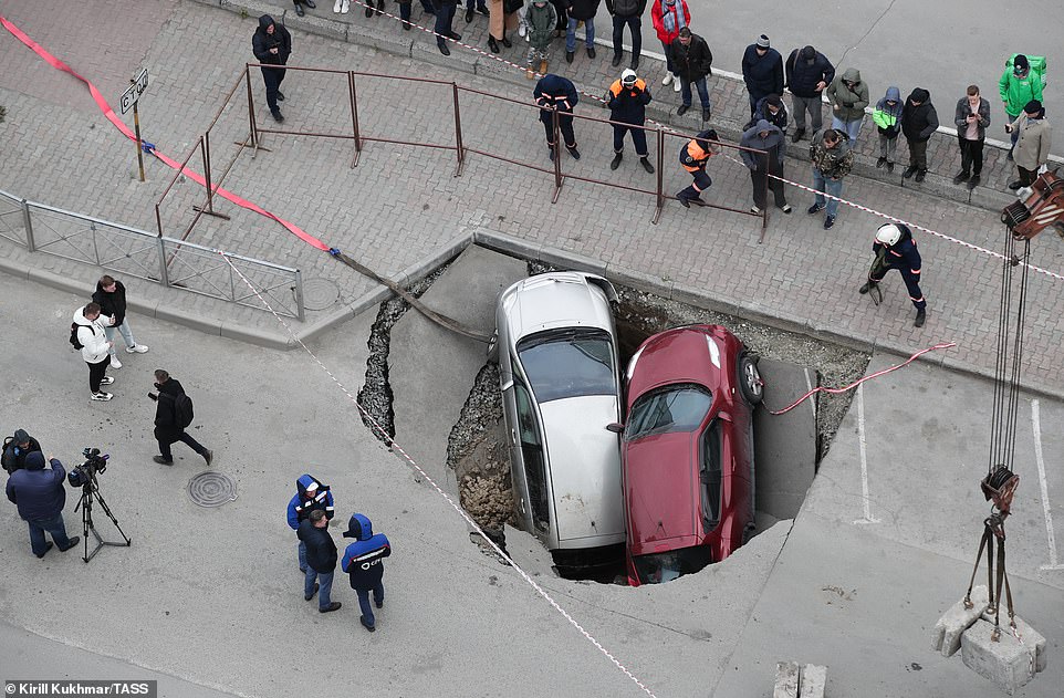 49113911-10087419-Two_cars_have_been_swallowed_by_a_sinkhole_full_of_piping_hot_wa-a-16_163412...jpg