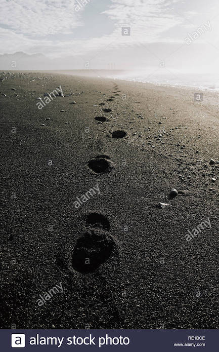 footprints-on-the-black-lava-sand-beach-of-jokulsarlon-in-south-east-iceland-RE1BCE.jpg